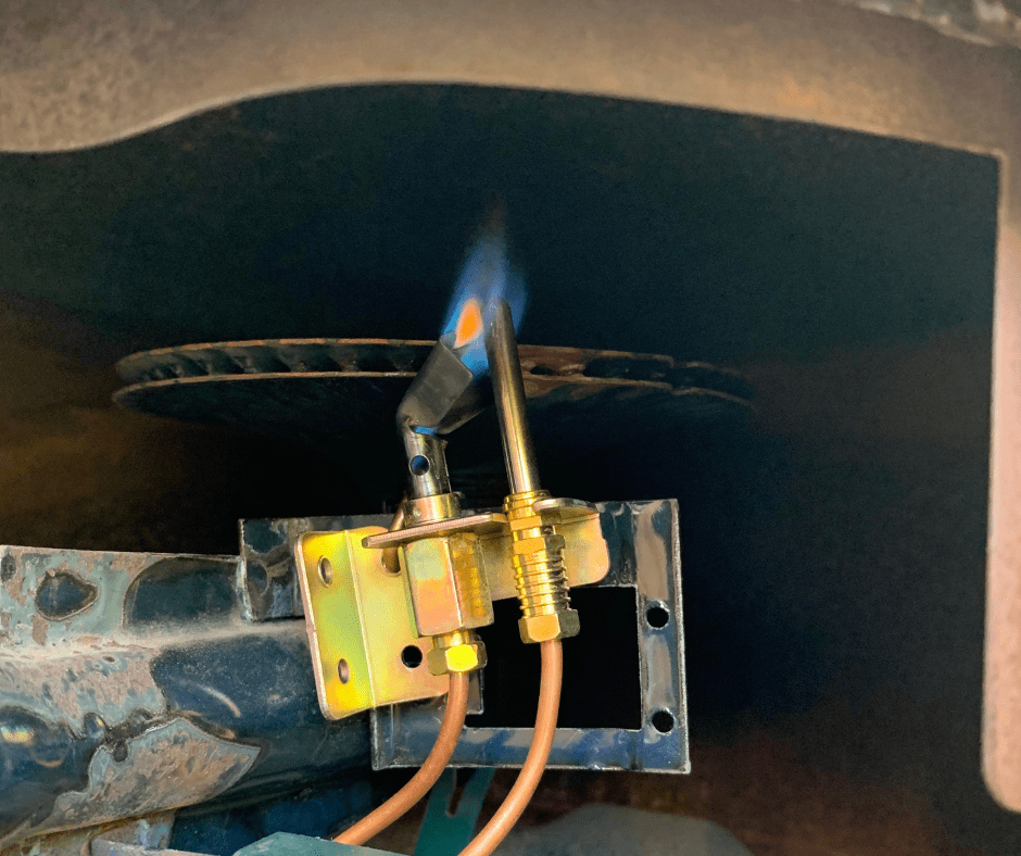 A lit pilot light in a gas tank water heater.