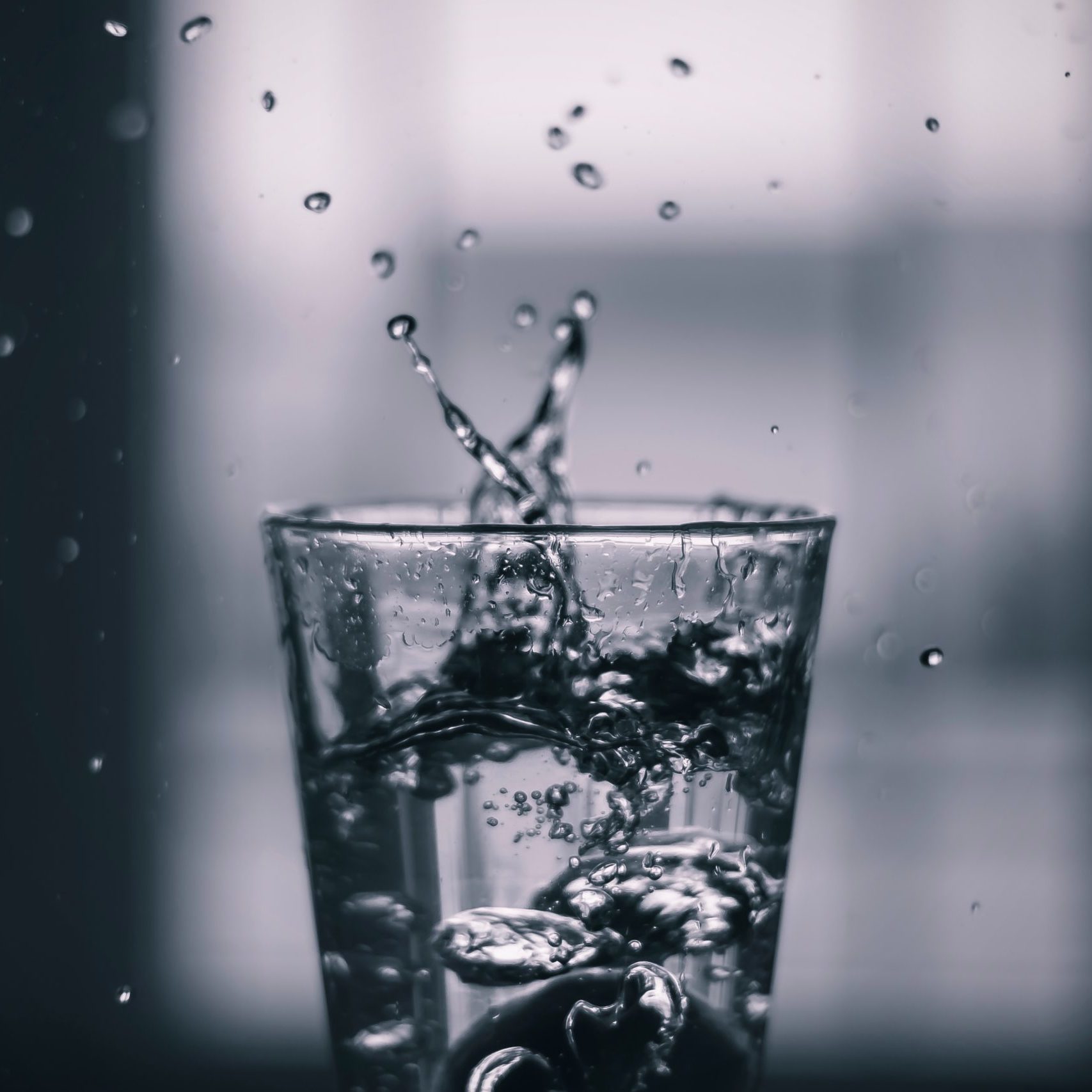 Clear glass of clean water with droplets splashing out
