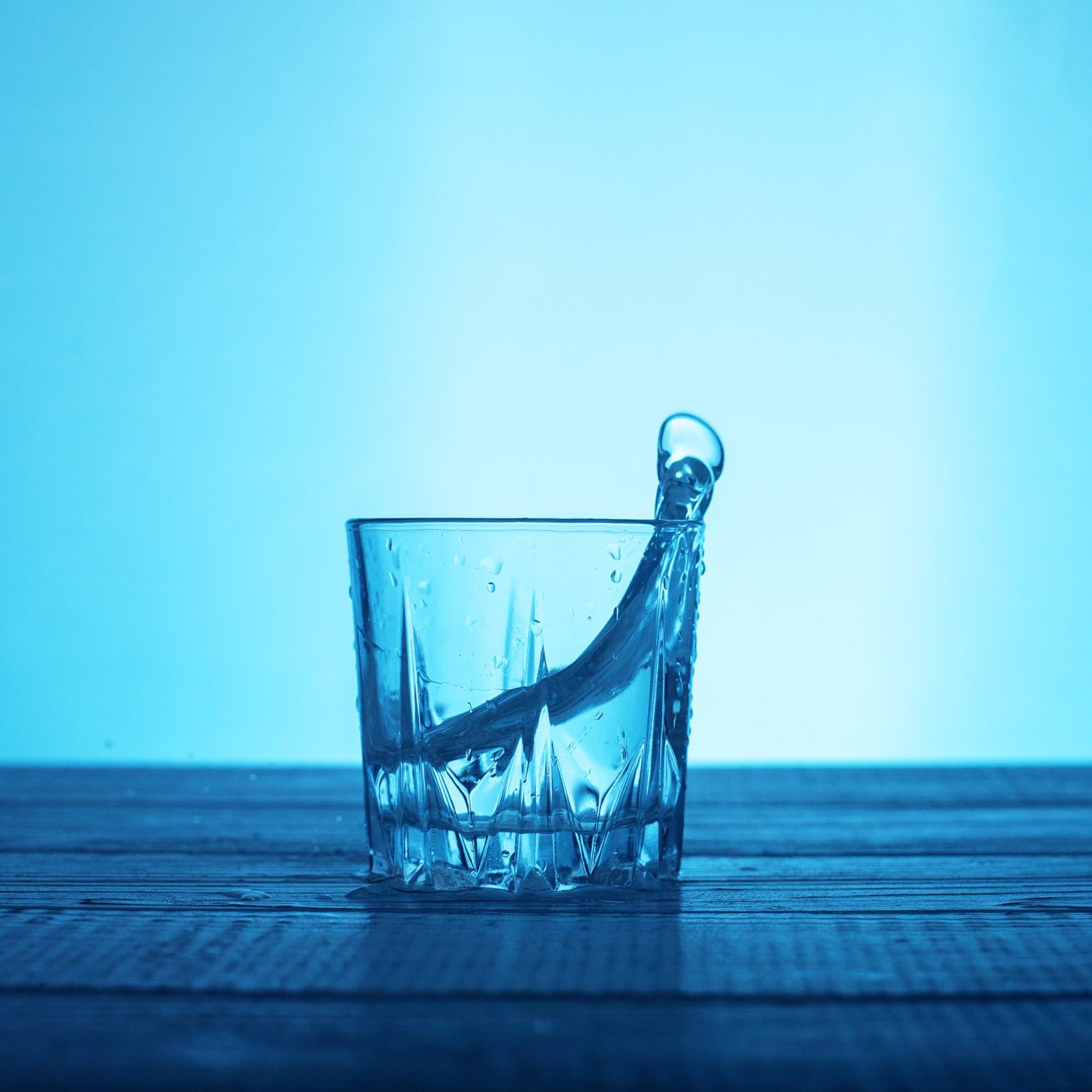 Glass of water with a splash forming on the right side