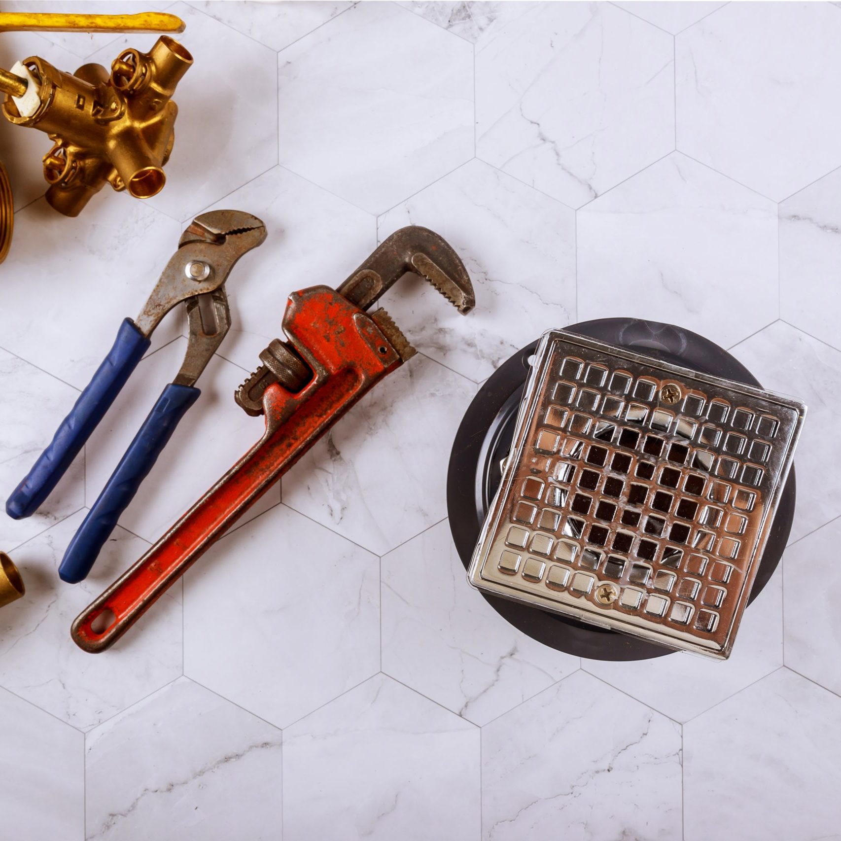 Shower Drain Repair: Plumbing Parts and Tools at the Ready Shower drain surrounded by various plumbing parts and tools